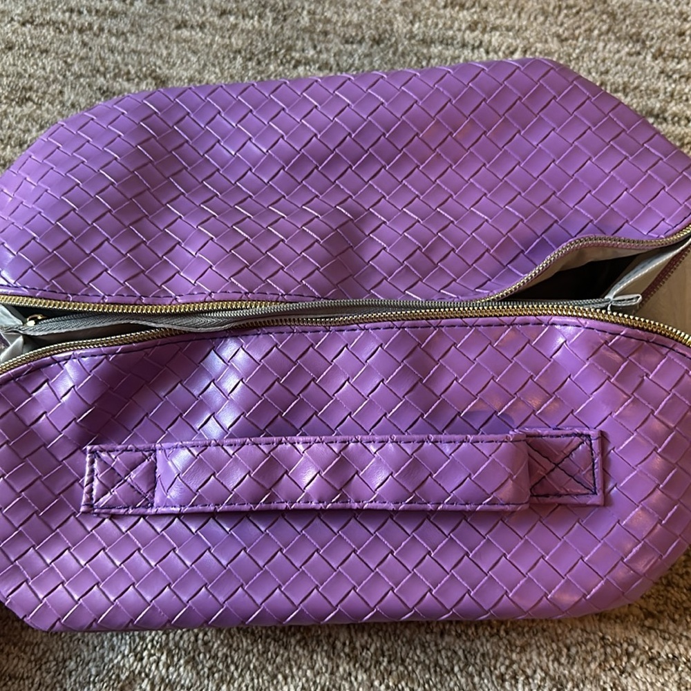 New in box cosmetic bag in purple faux leather weave with handle and pockets